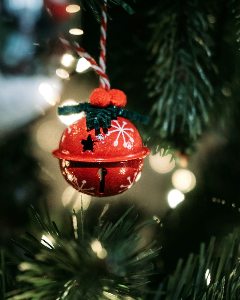 um ornamento de sino vermelho pendurado de uma árvore de Natal