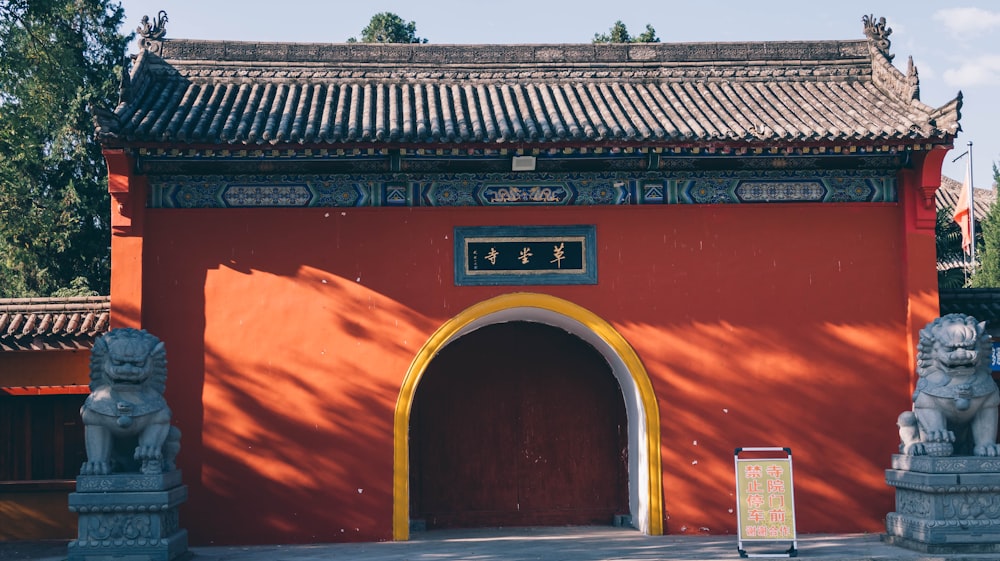 a red building with statues in front of it