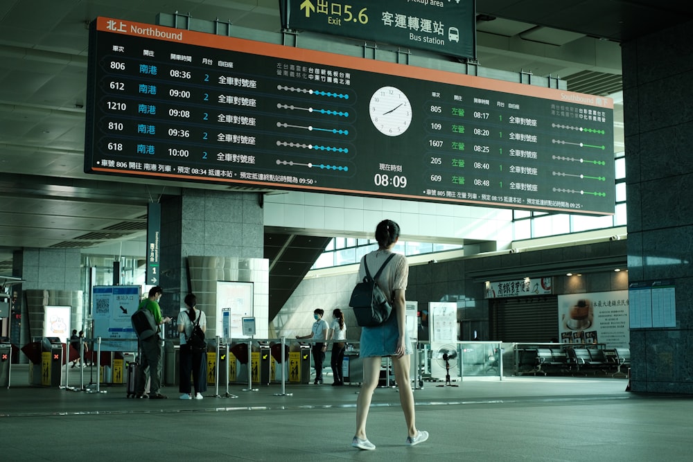 a woman is walking through an airport terminal