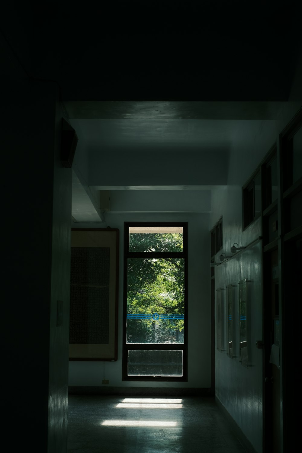 a dimly lit hallway with a large window