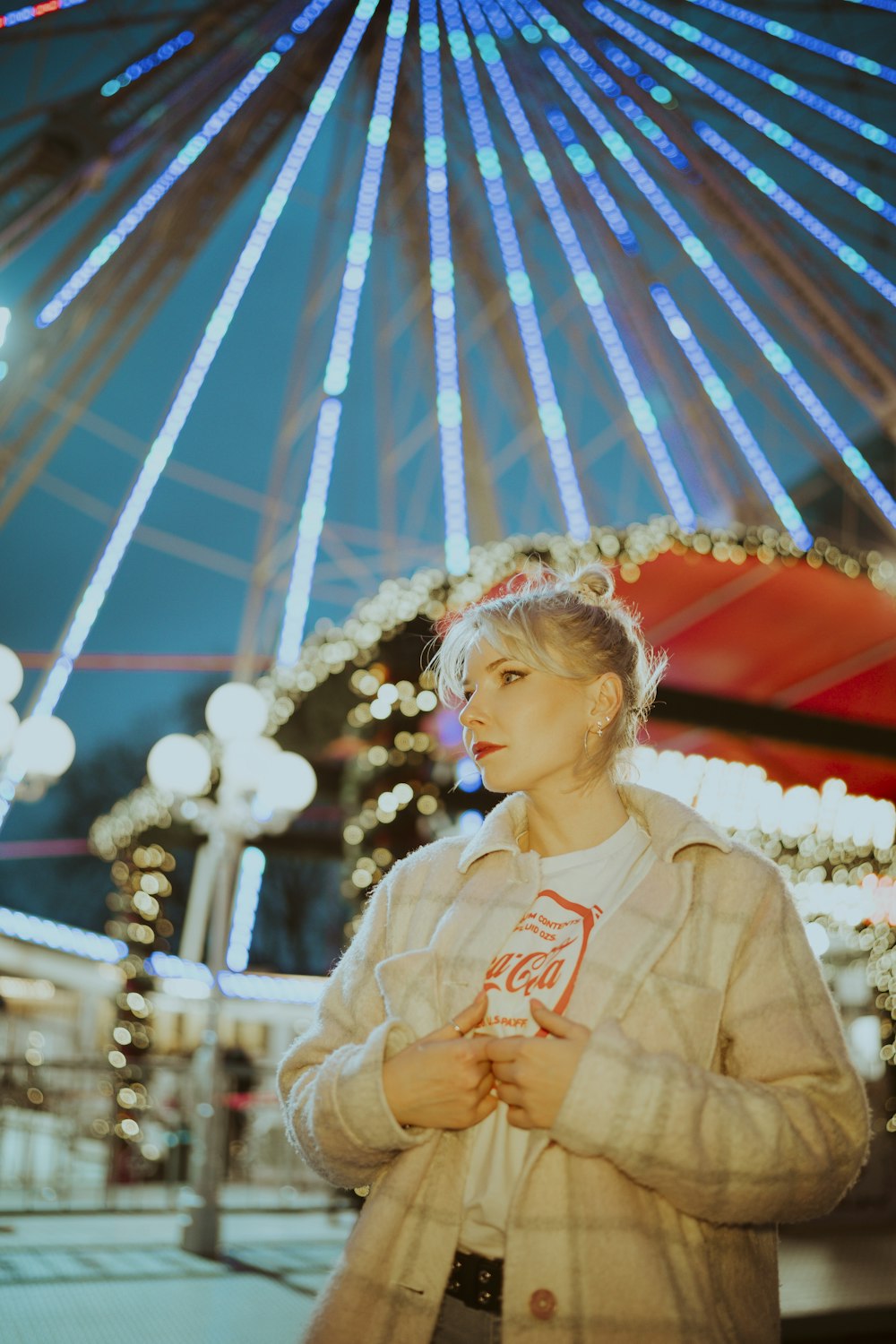 a woman standing in front of a ferris wheel
