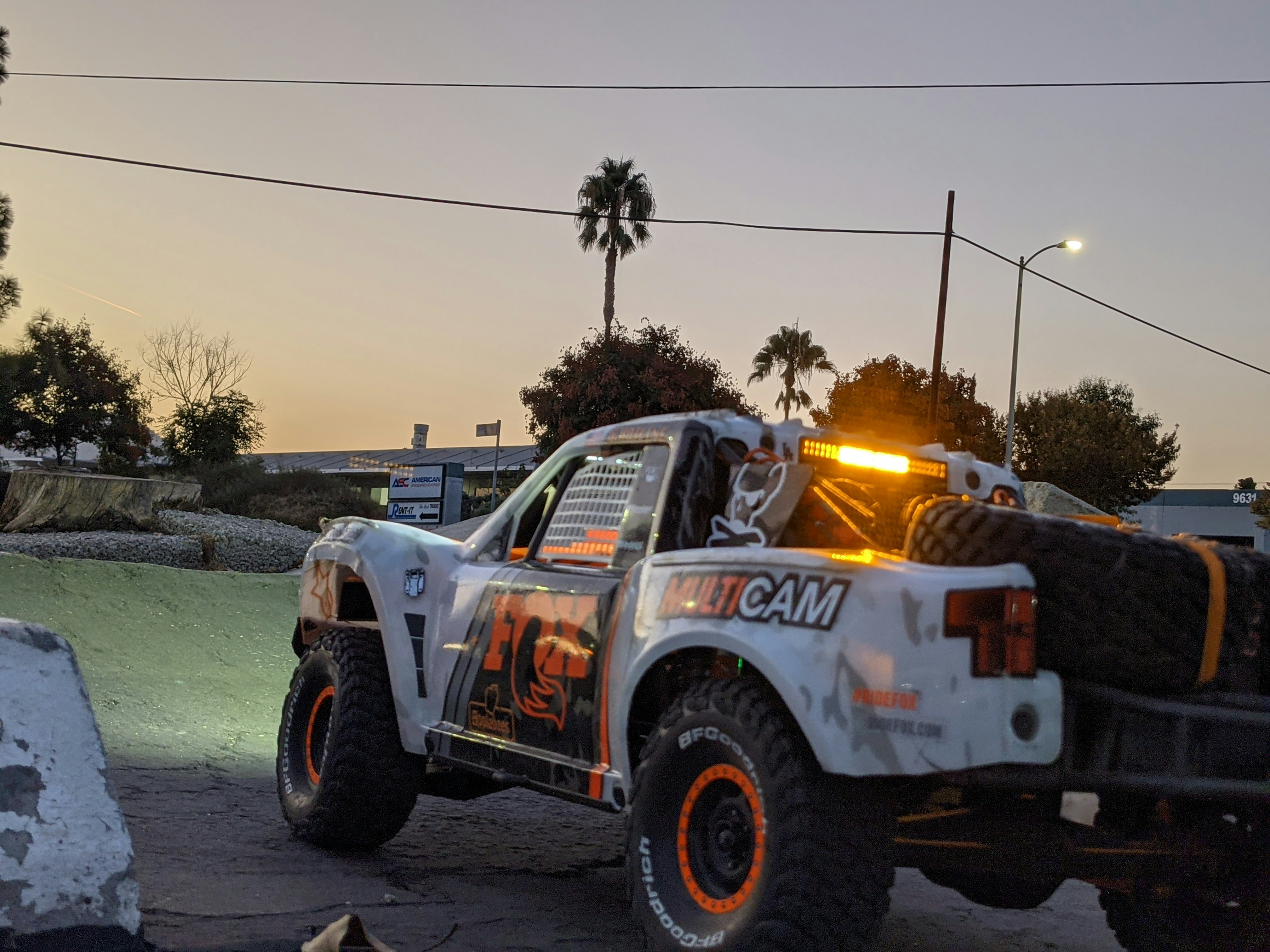 a truck with lights on driving down a street
