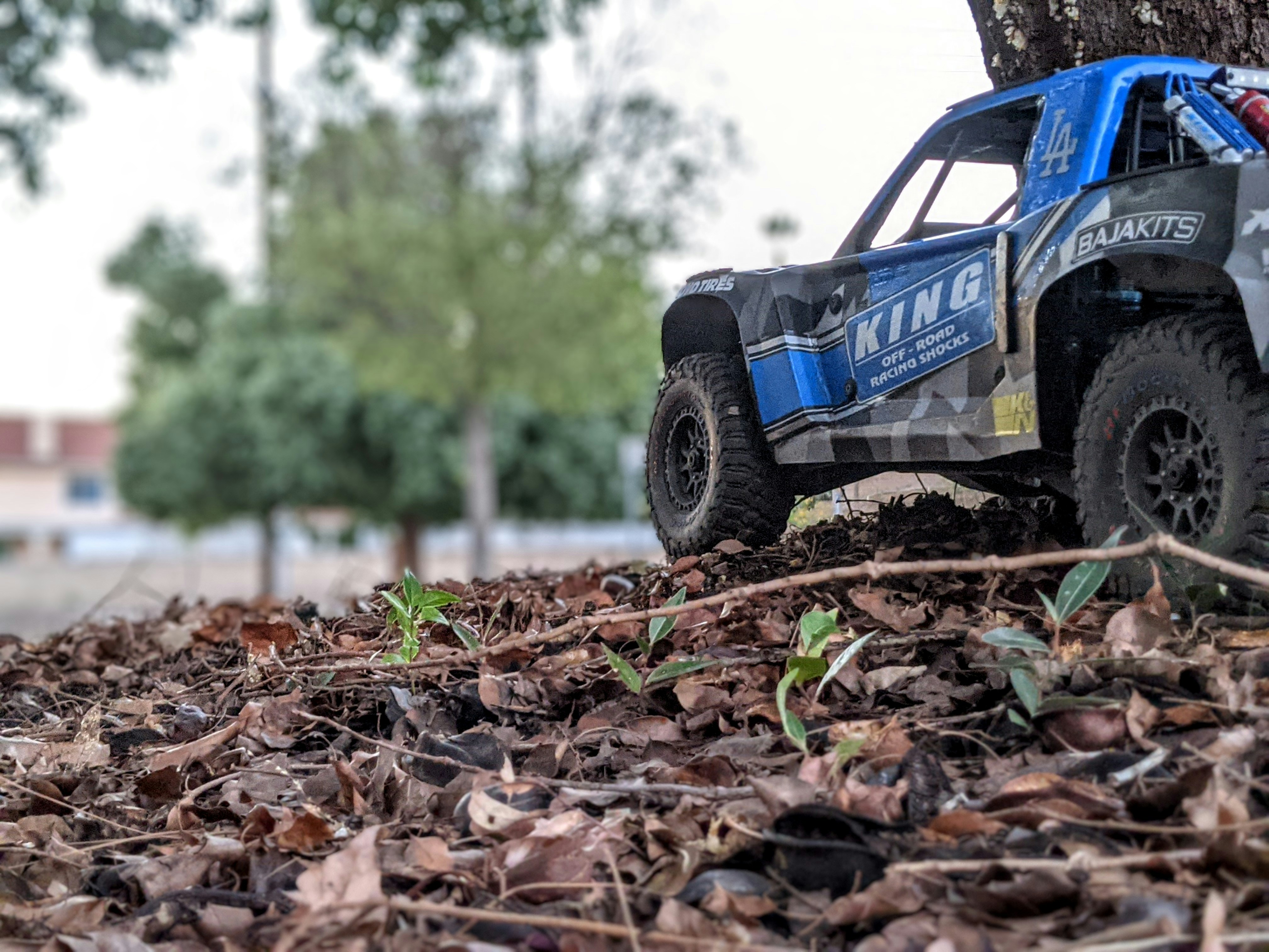 a toy truck is parked next to a tree