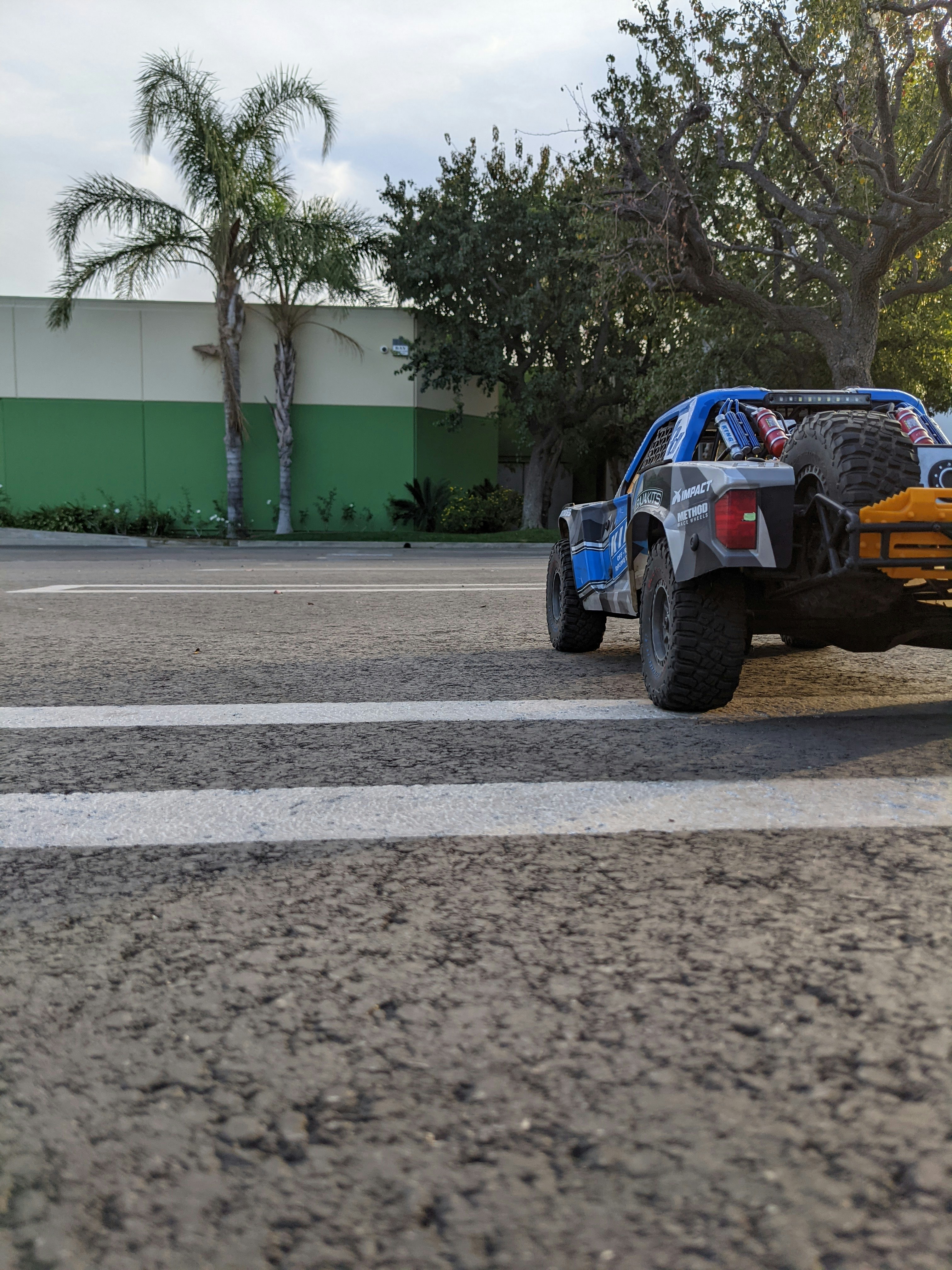 a monster truck driving down a street next to a building