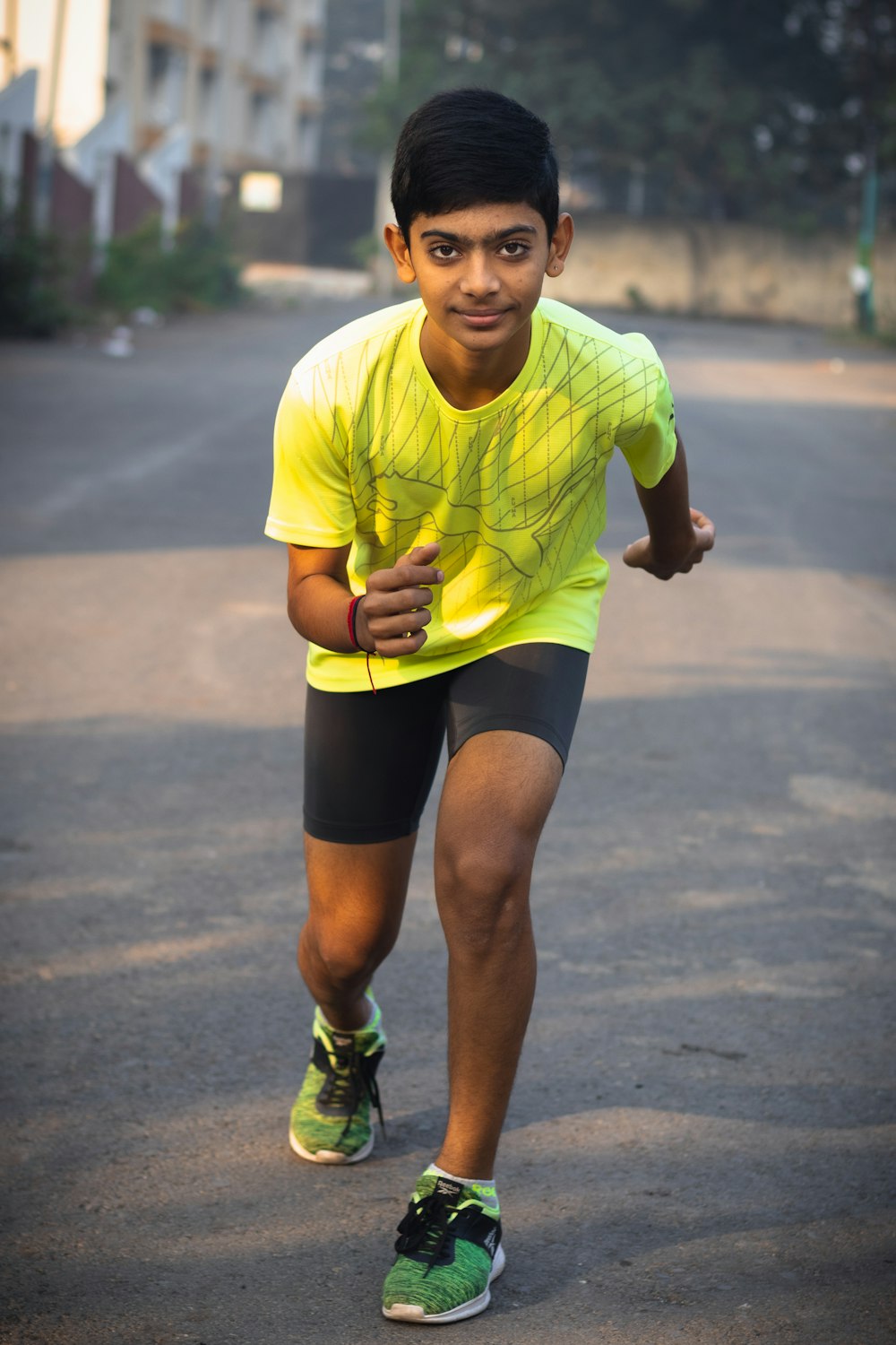 a young man in a yellow shirt is running