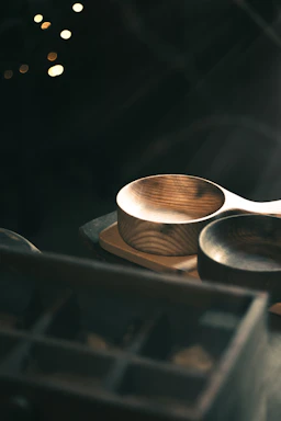 A warm, inviting photo of a rustic wooden table with bowls of colorful Indian grains and lentils, softly lit by natural light.