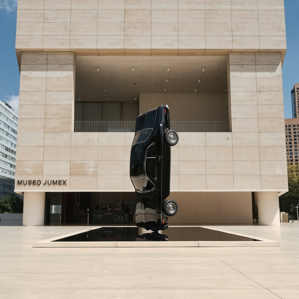 a black bus parked in front of a building