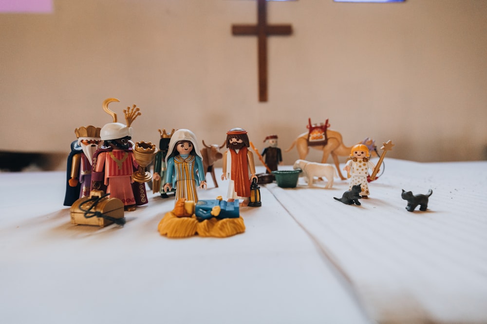a table topped with figurines of people and animals