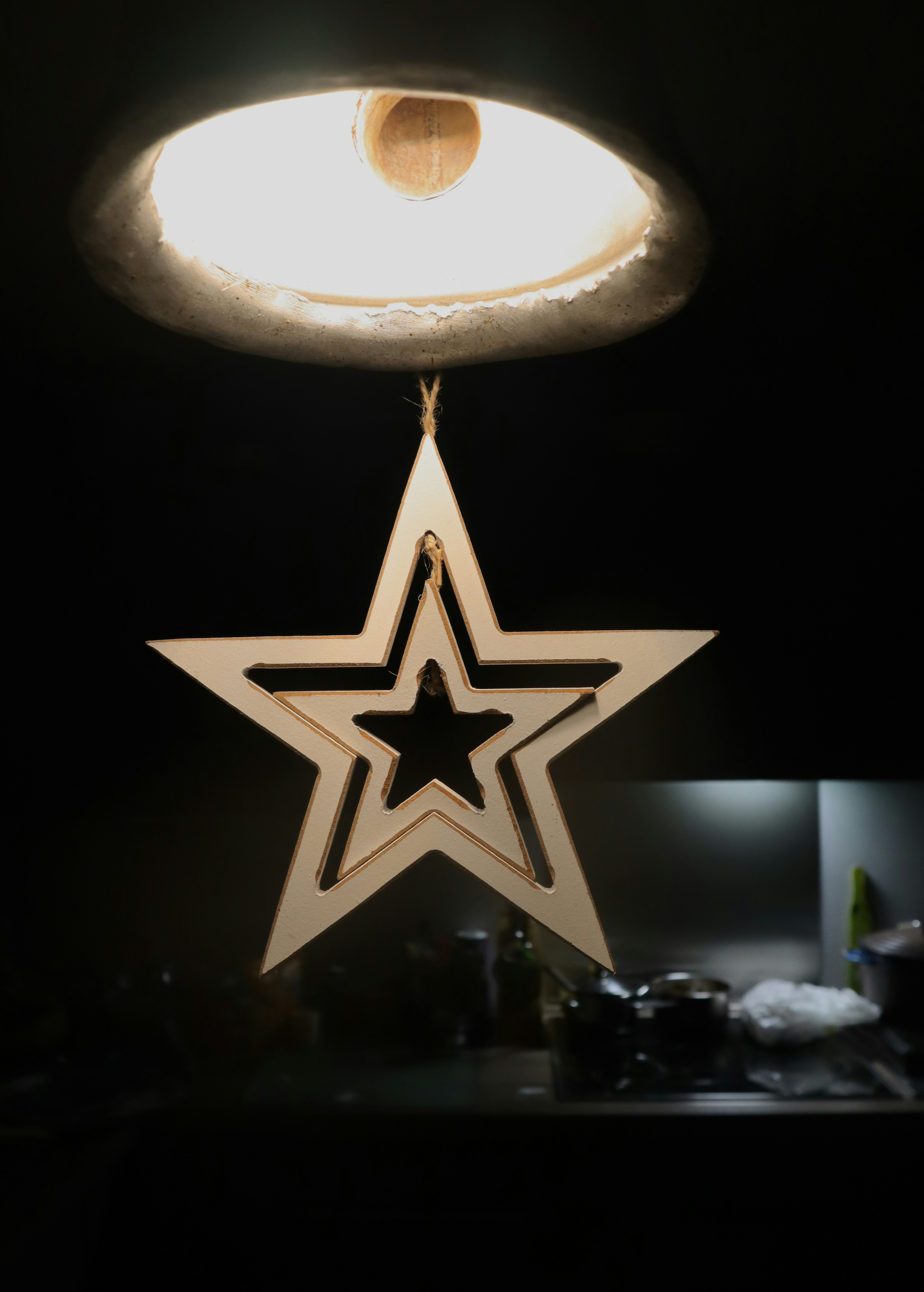 uma estrela de madeira pendurada em uma luminária