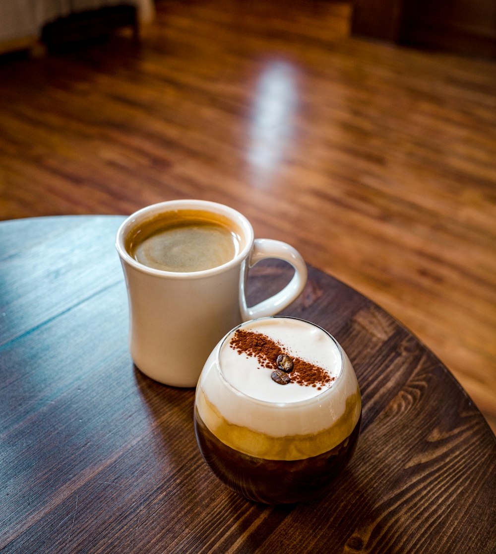 a cup of coffee sitting on top of a wooden table