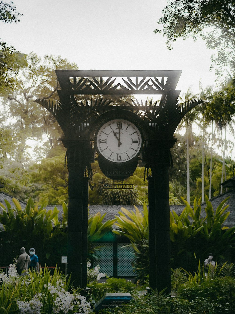 a large clock in the middle of a garden