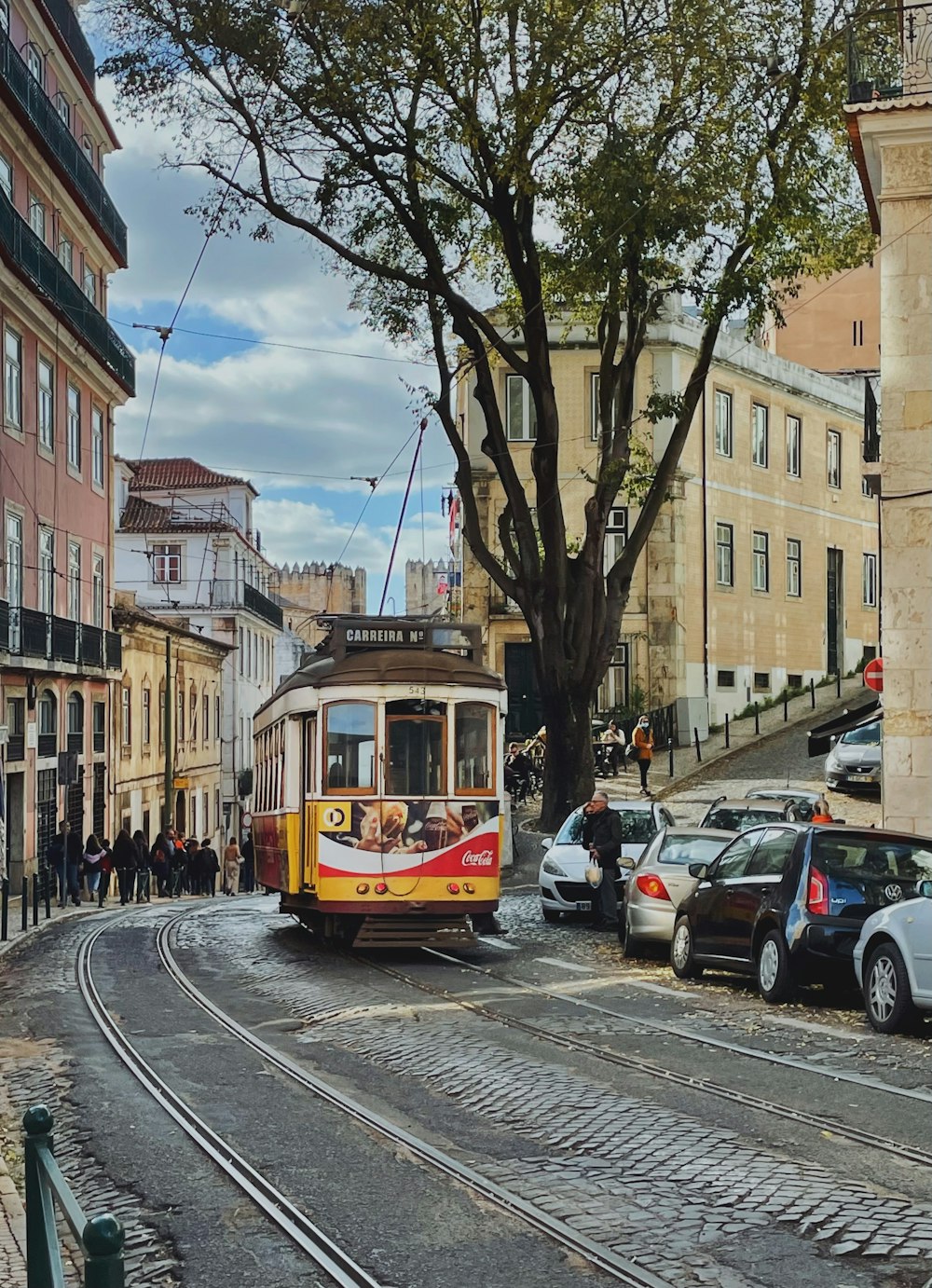 Un tram giallo e rosso che viaggia lungo una strada