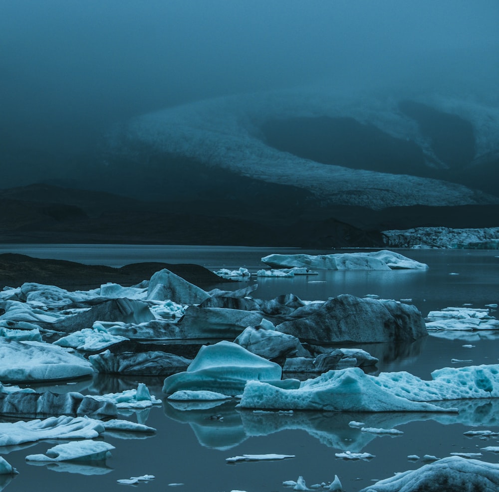 a group of icebergs floating on top of a body of water