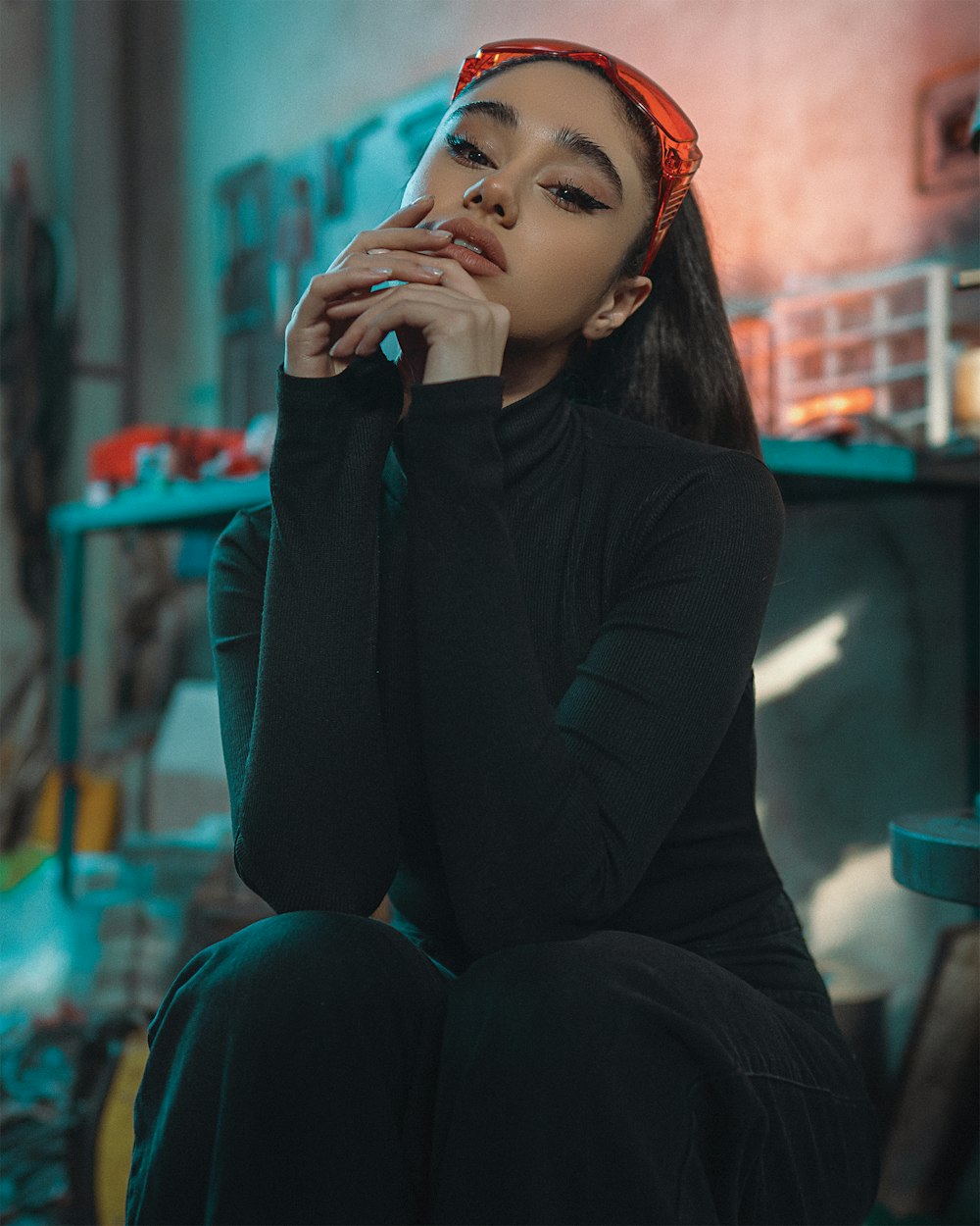 a woman sitting on a chair with her hand on her face