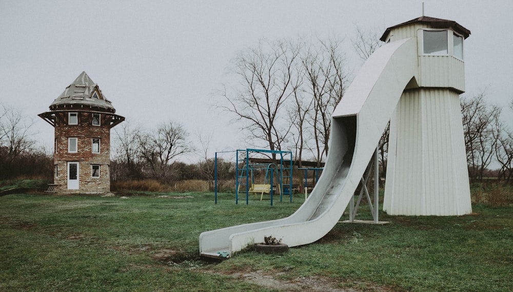 a slide in the grass next to a building