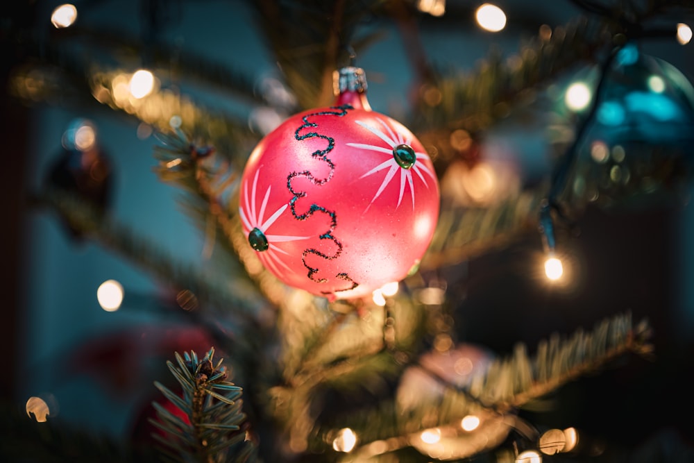 a red ornament hanging from a christmas tree