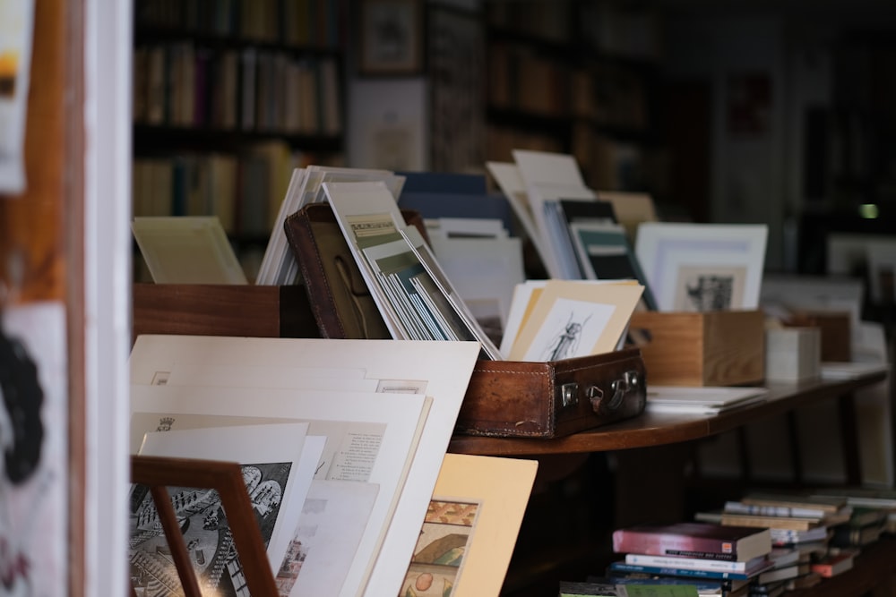 a bookshelf filled with lots of books on top of a wooden table