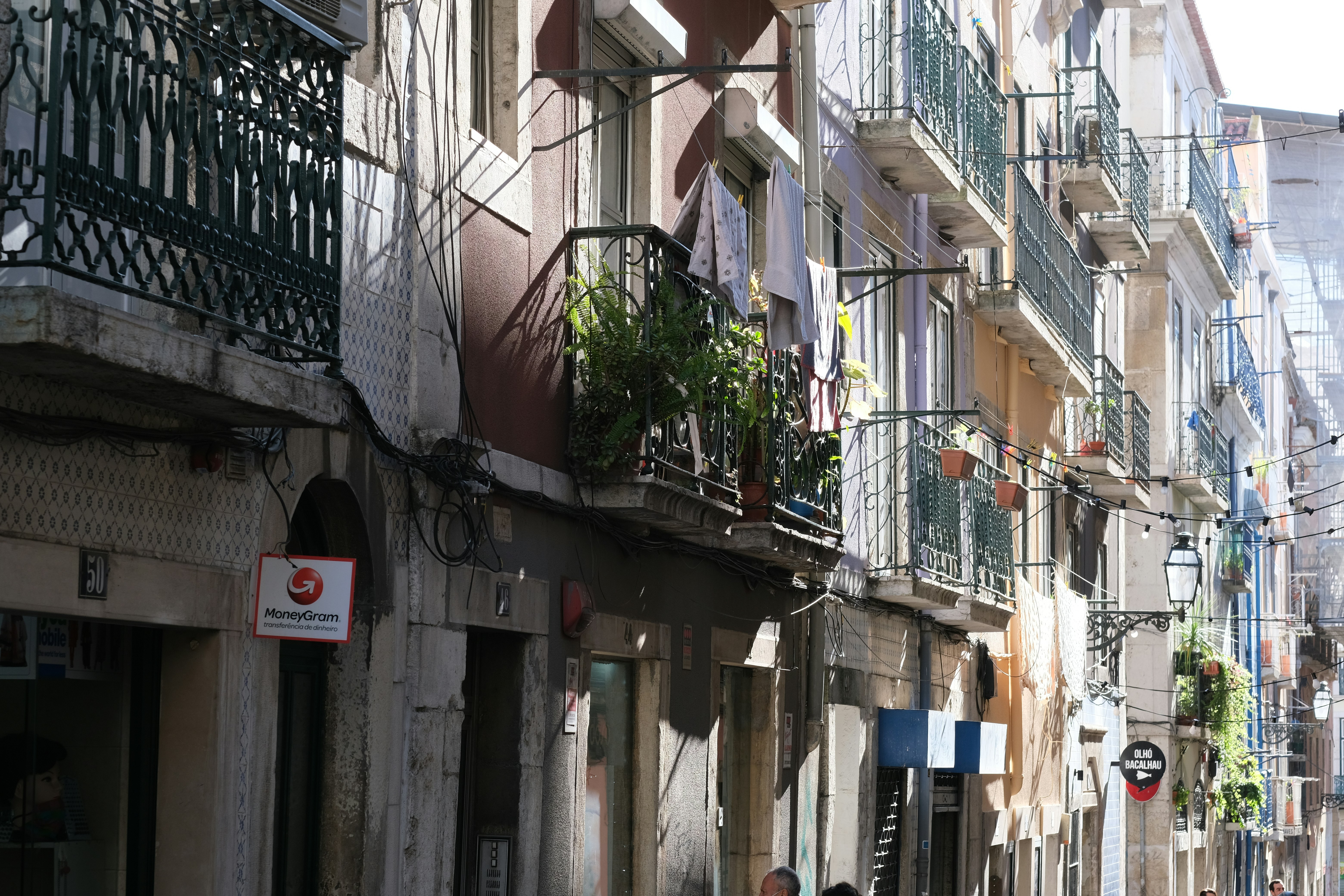 a man walking down a street next to tall buildings