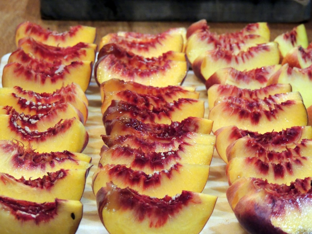 a wooden cutting board topped with slices of fruit