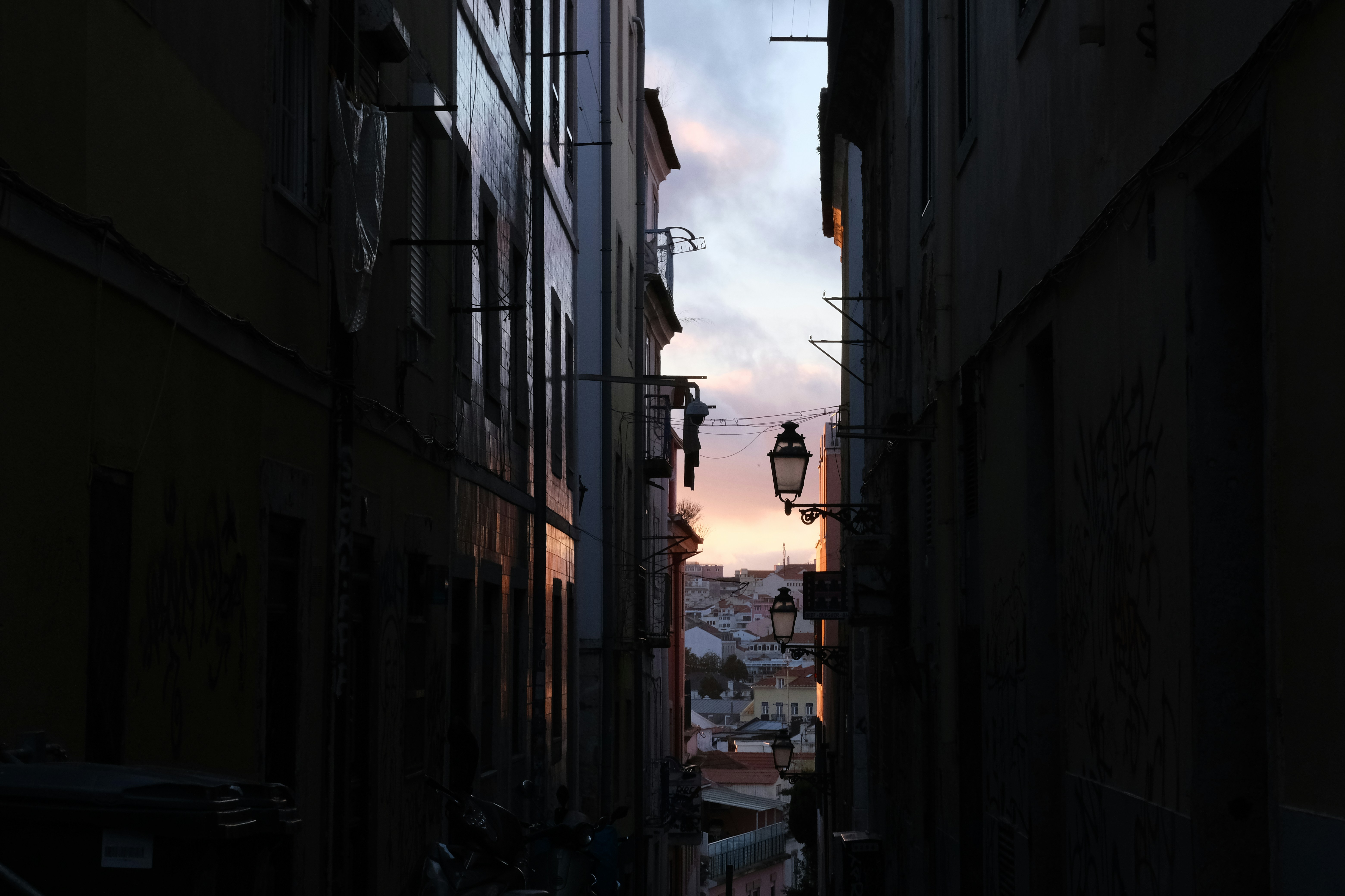 a narrow alley way with a street light in the distance
