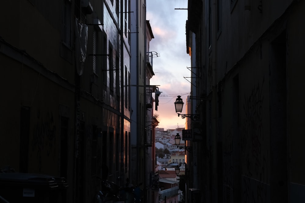 a narrow alley way with a street light in the distance