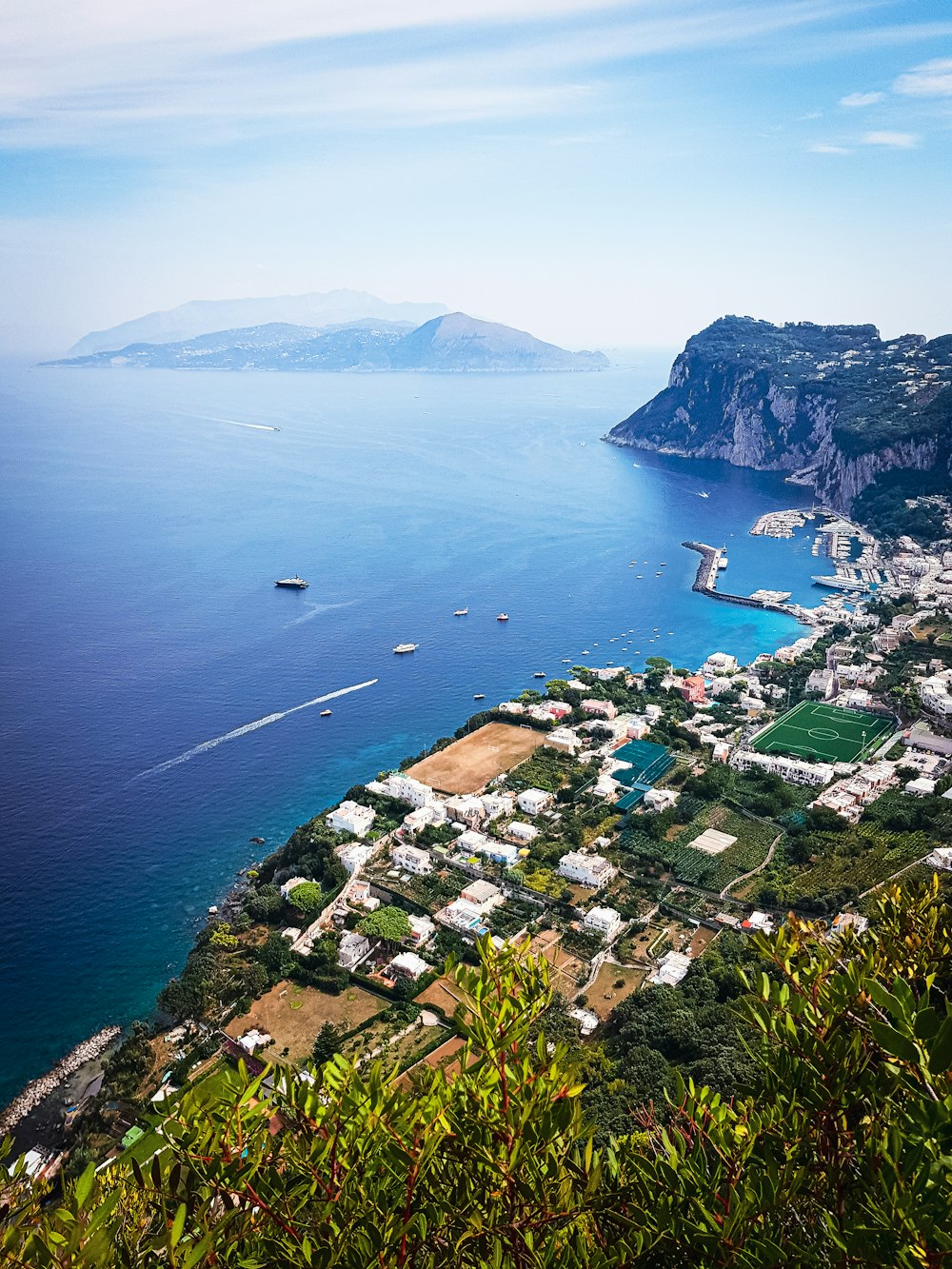 a scenic view of a small town on the edge of a large body of water