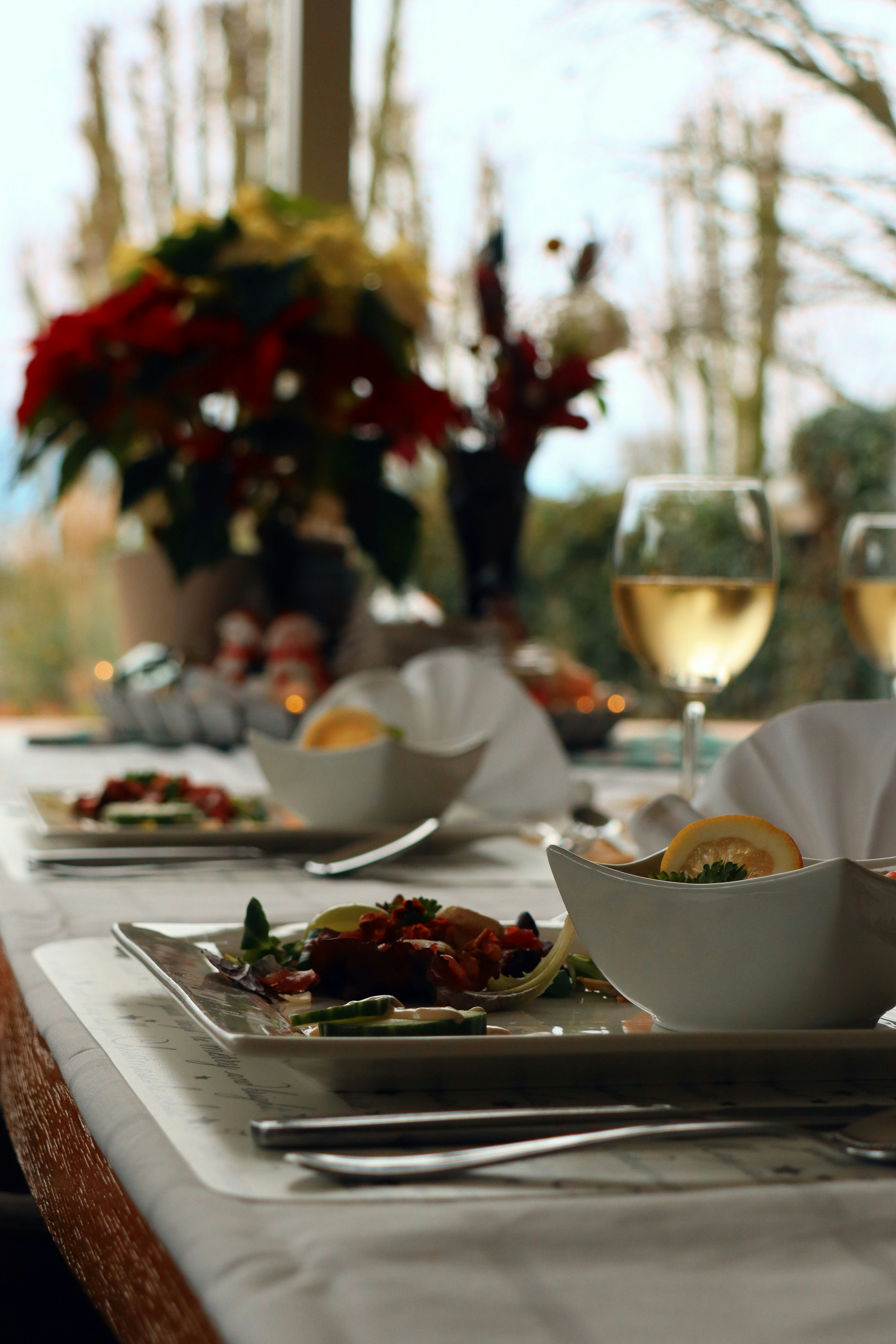 a table with plates of food and glasses of wine