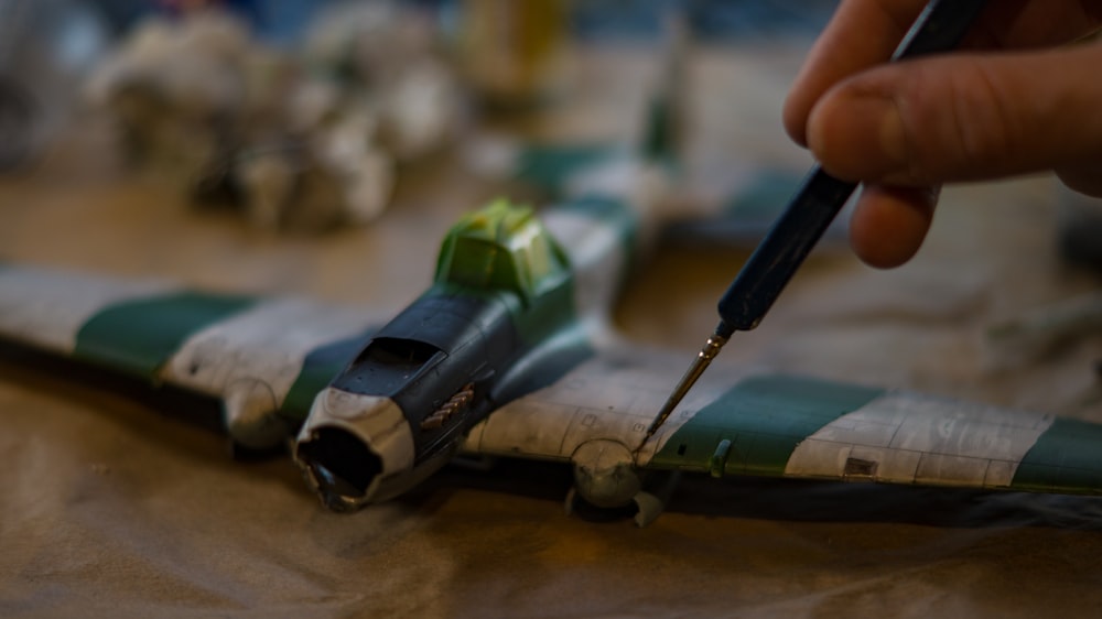 a person is painting a model of a fighter jet