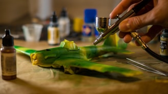 A person painting a model plane with a airbrush