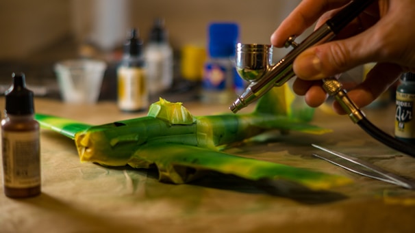 A person painting a model plane with a airbrush