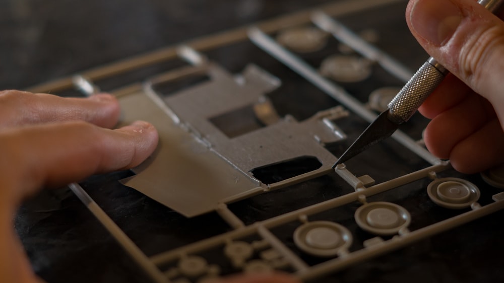 a close up of a person cutting a piece of metal