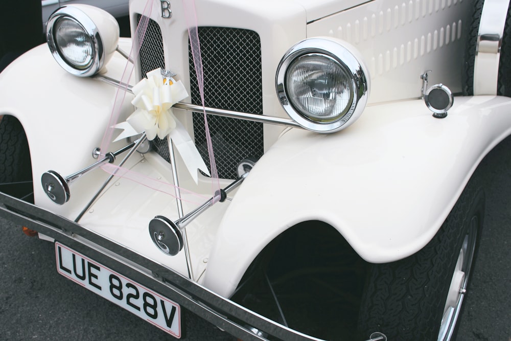 a white car with a flower on the front of it