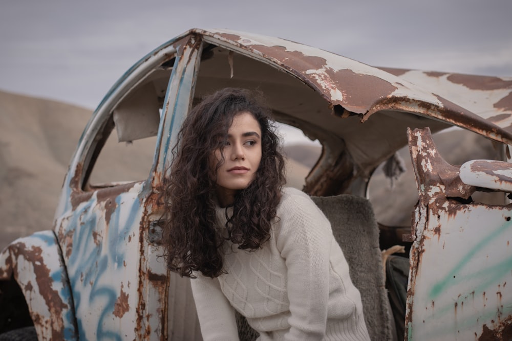 a woman standing in front of an old car