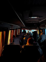 a group of people sitting on a bus at night