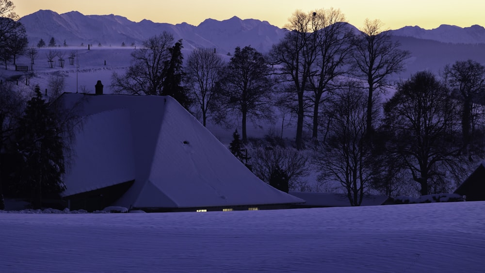 a tent in the snow with mountains in the background