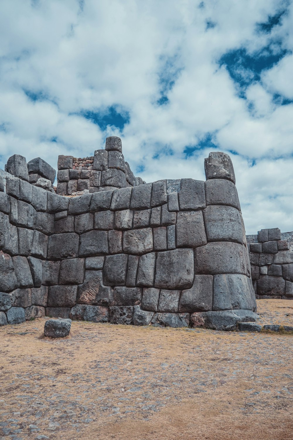 uma grande estrutura de pedra sentada em cima de um campo de grama seca