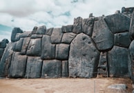 a stone wall made of rocks with a sky in the background