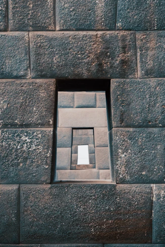 a small window in the side of a stone wall