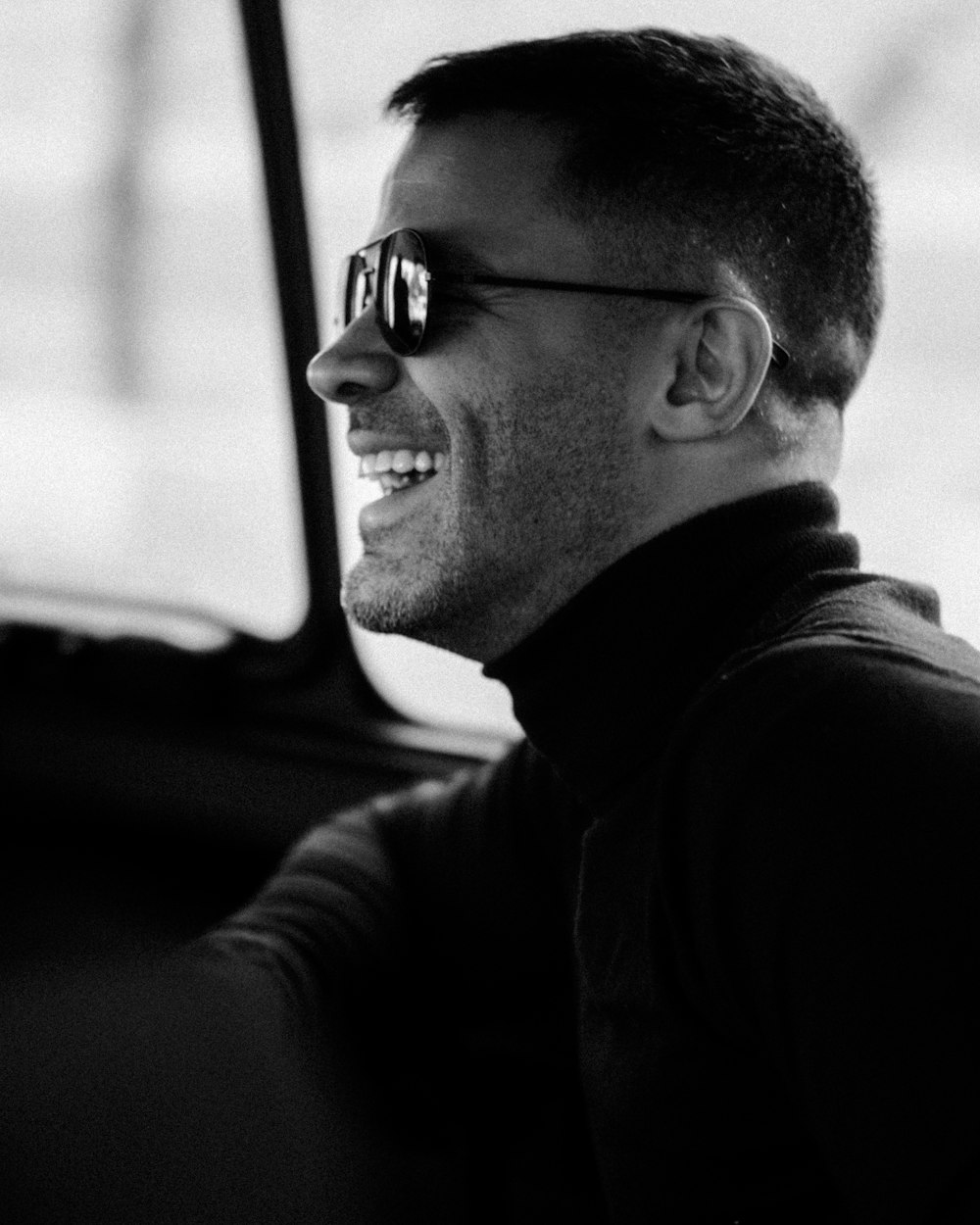 a man sitting in a car wearing sunglasses