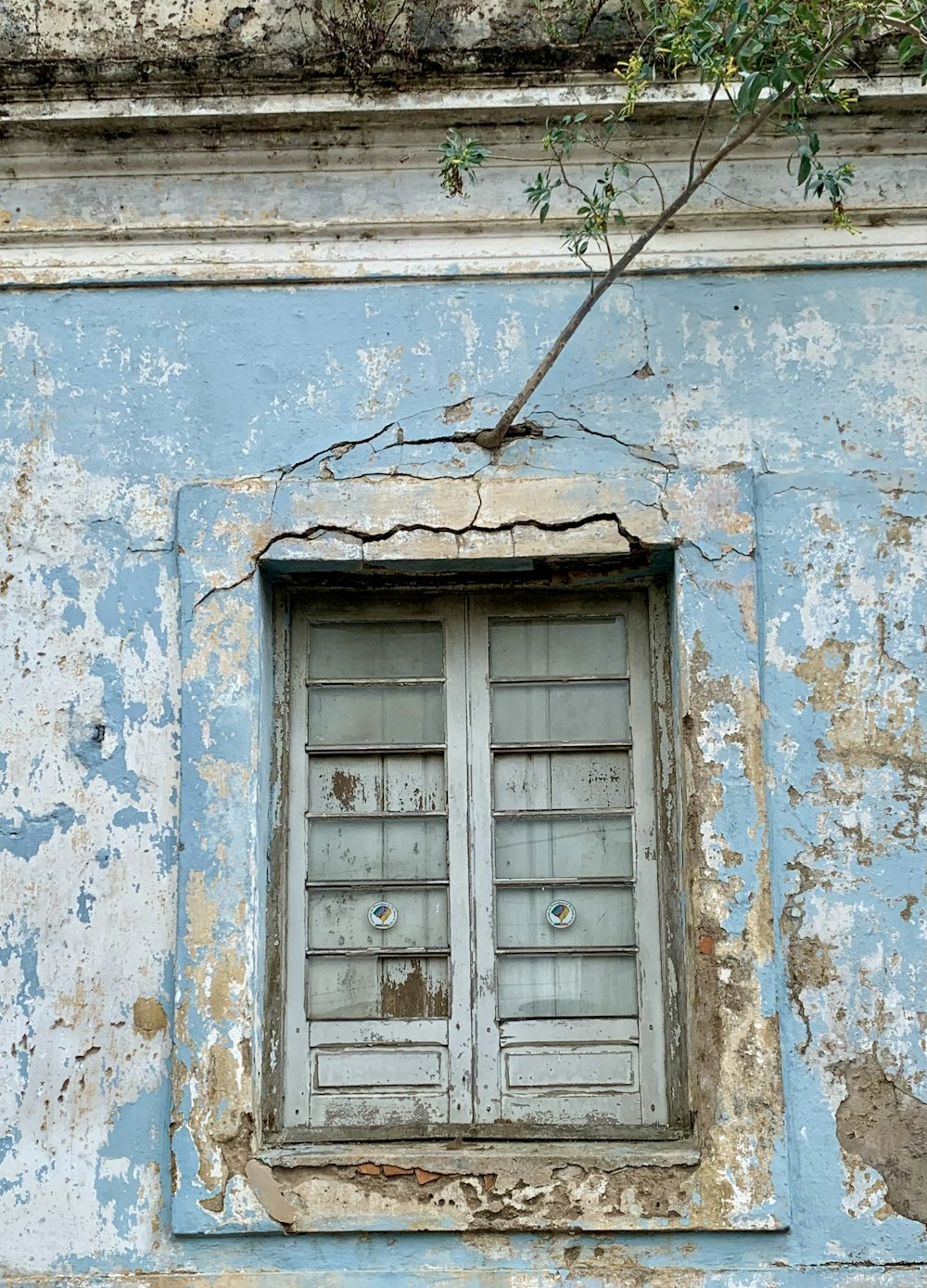 an old building with peeling paint and a broken window