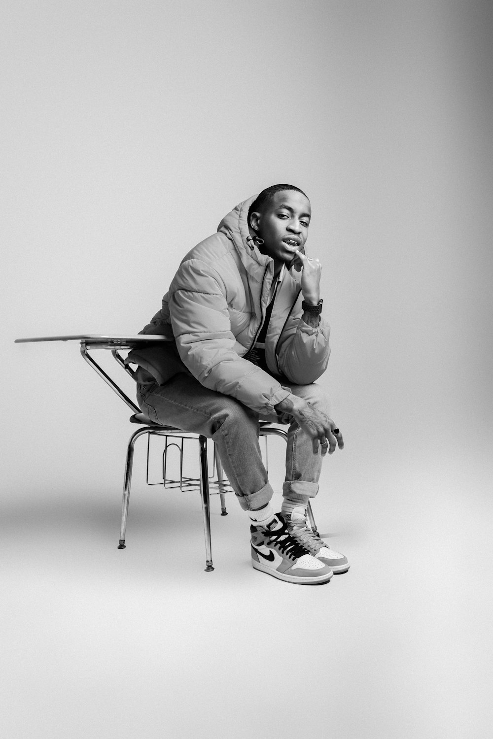 a black and white photo of a man sitting on a chair