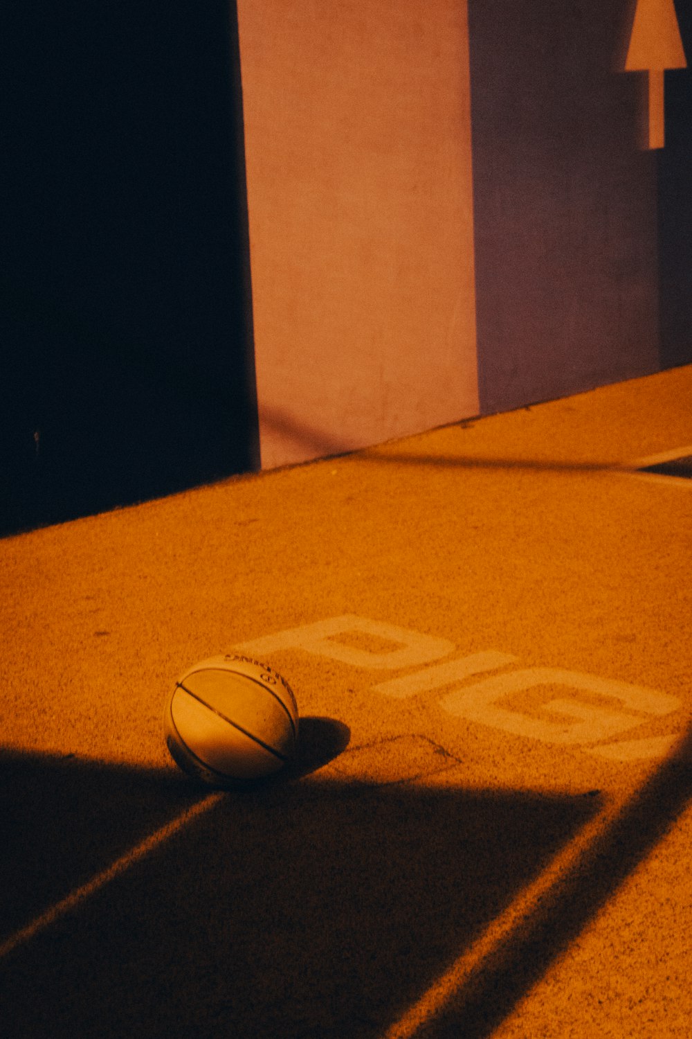 un ballon de basket posé sur le sol à côté d’un bâtiment