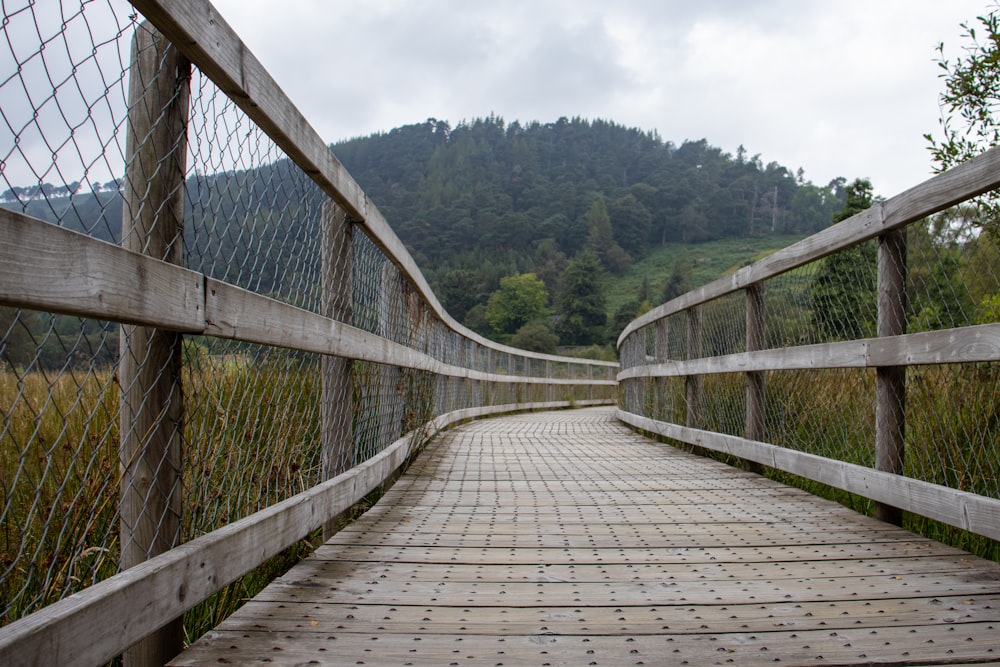 a wooden bridge with a wire fence over it