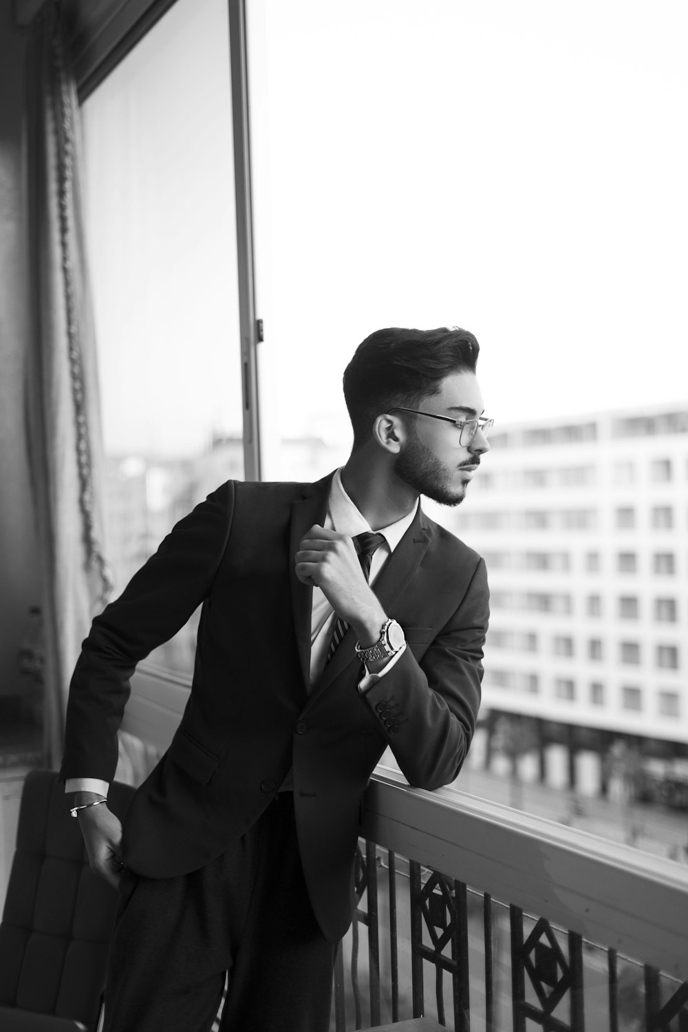 a man in a suit and tie standing on a balcony