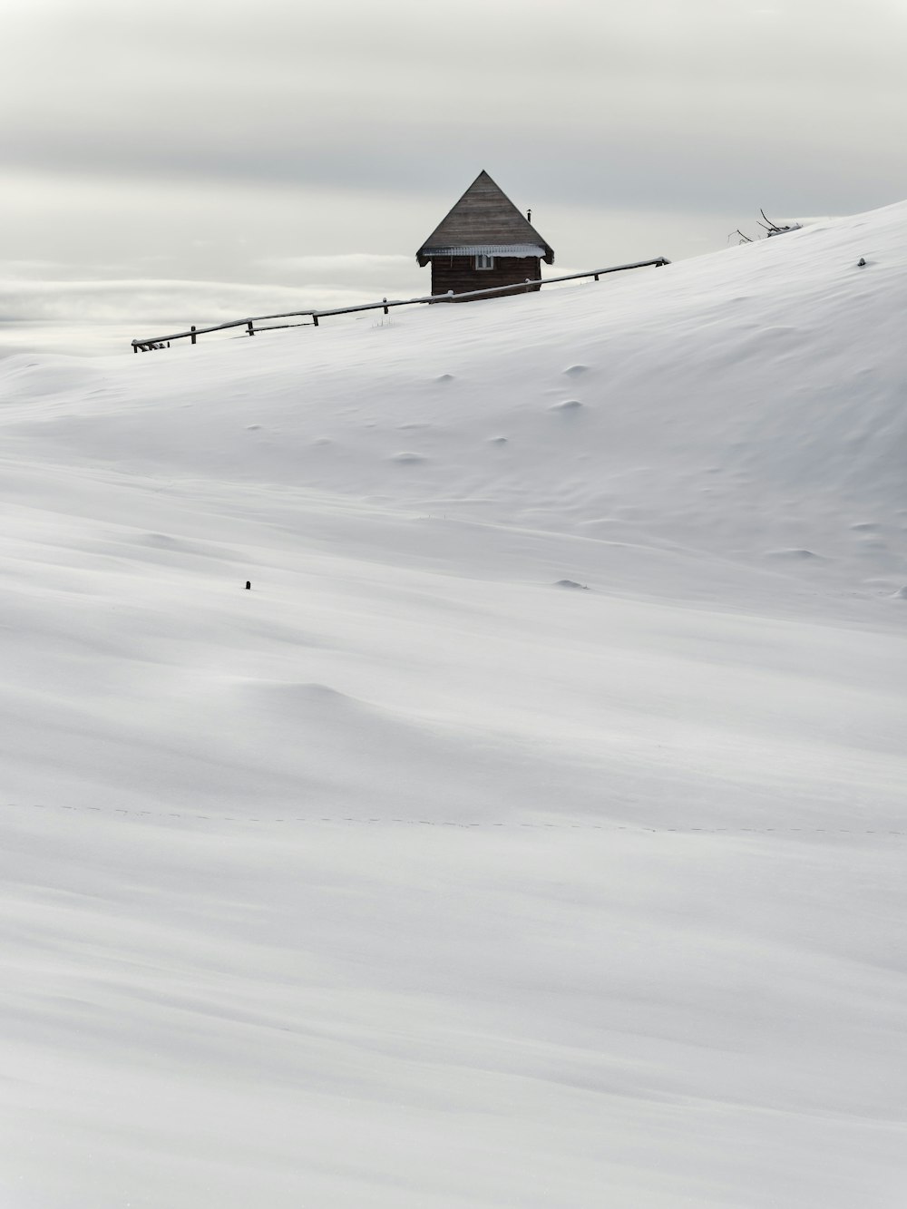 a house sitting on top of a snow covered hill