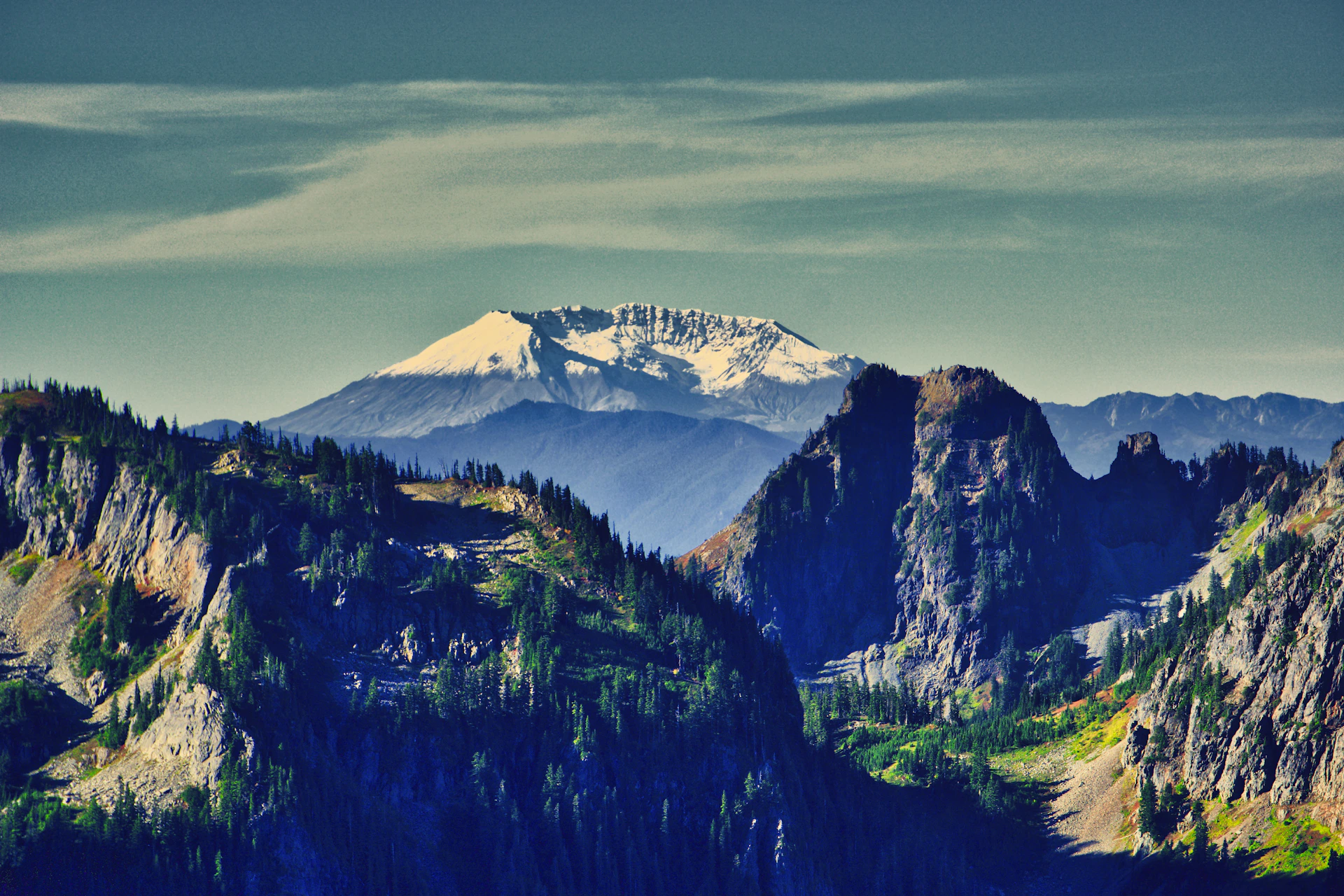 a mountain range with trees and mountains in the background
