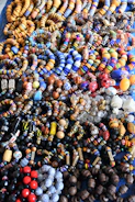 Handcrafted beaded necklaces and bracelets laid out on a colorful tapestry
