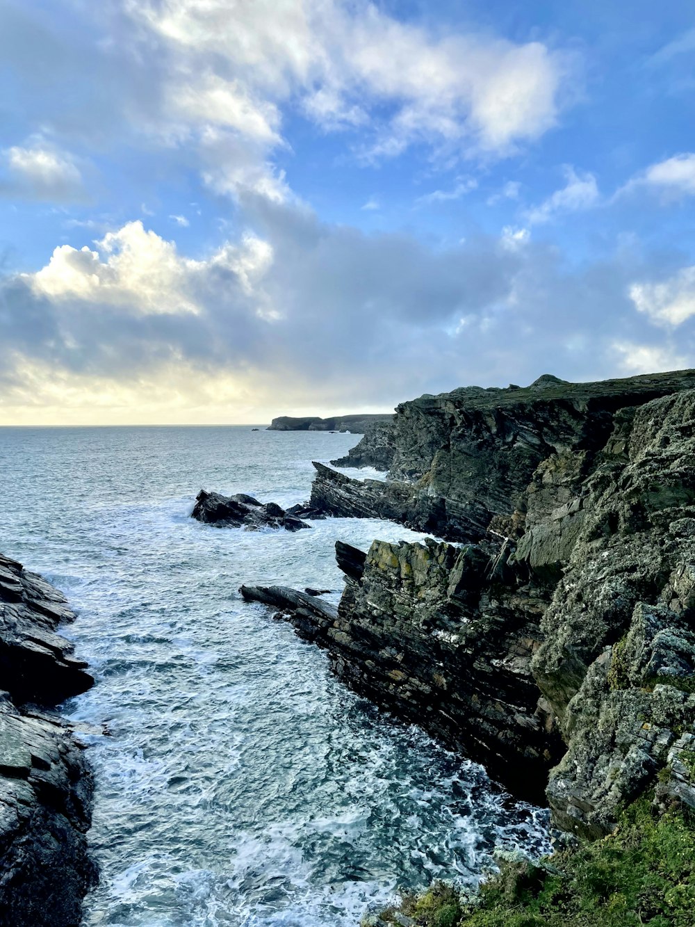 a large body of water next to a rocky cliff