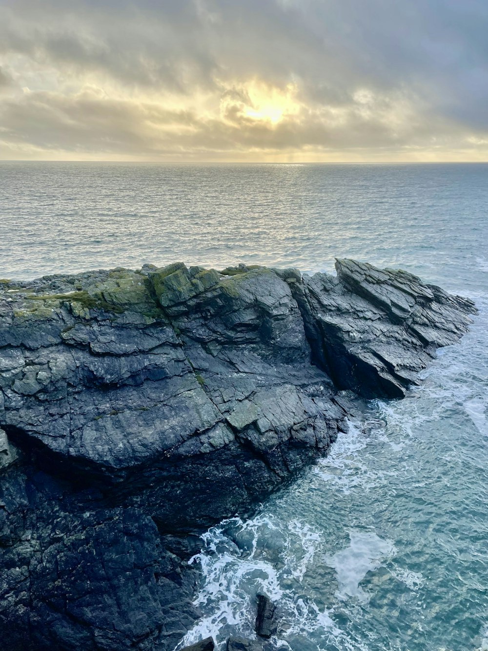 a large body of water next to a rocky shore