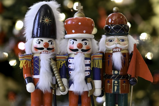 a group of nutcrackers standing next to a christmas tree